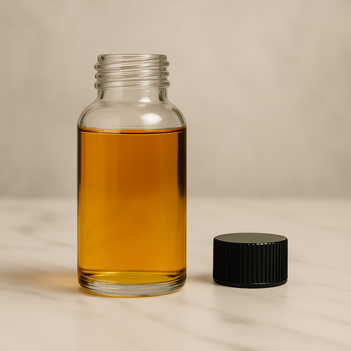 Banana Unisex fragrance oil in a clear glass roll-on bottle with gold cap on marble surface
