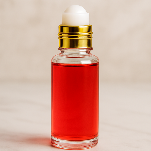 Small clear glass roller bottle filled with red fragrance oil with a white rollerball and gold collar on a marble surface, Viking By Creed Men inspired scent